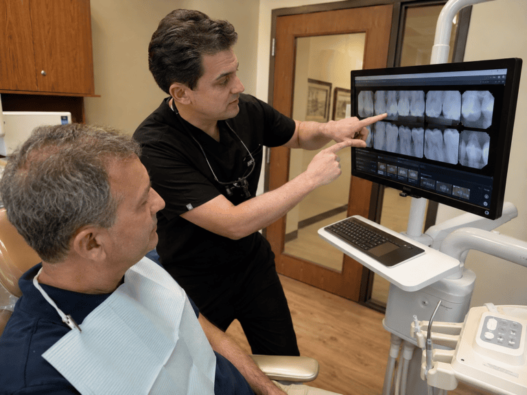 Dentist explaining dental treatment priorities to a patient during a treatment-planning consultation.